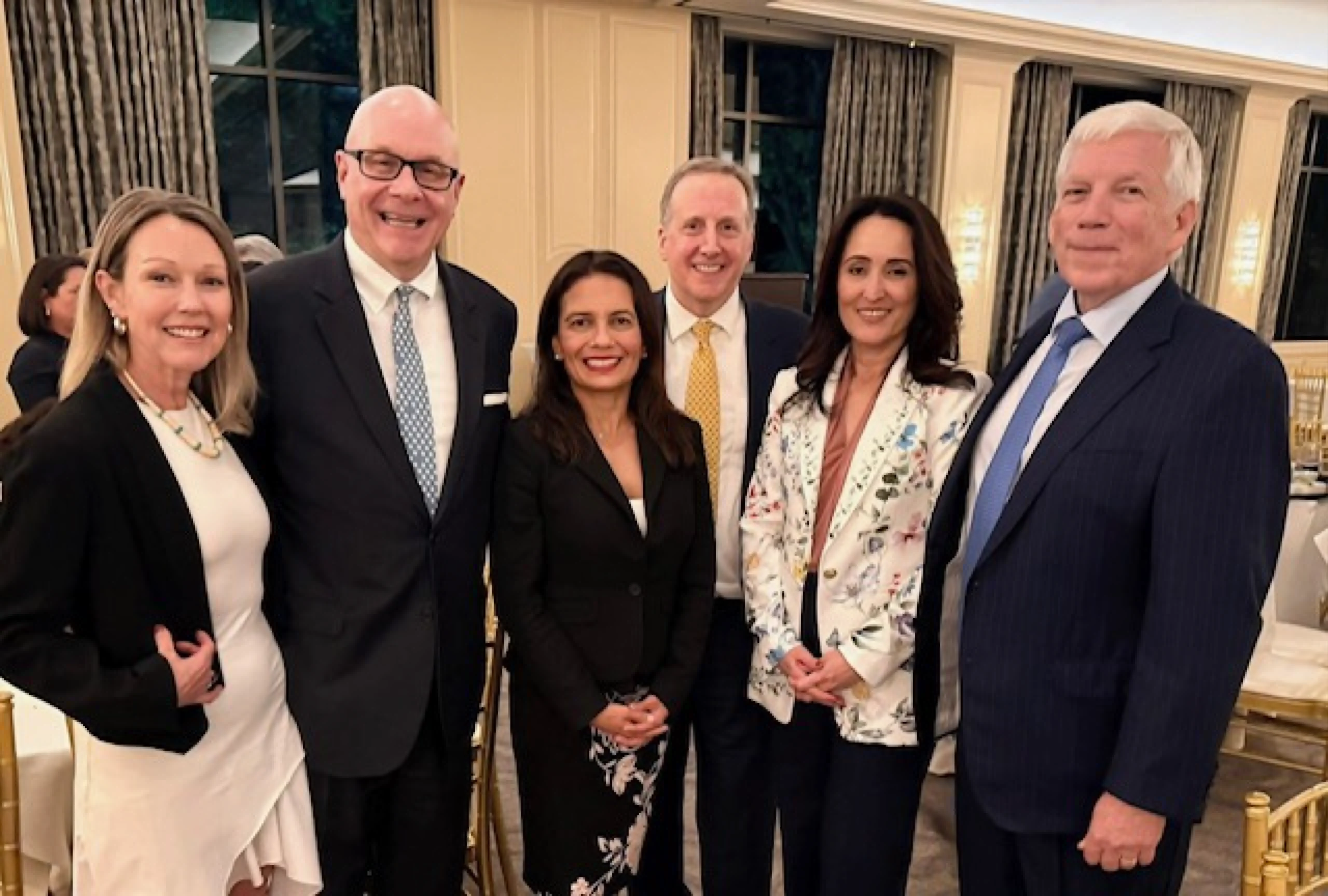 Former Justice Julie Countiss poses with colleagues and supporters at a professional event, highlighting her